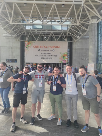 Me and 4 colleagues standing in front of the main KubeCon entry